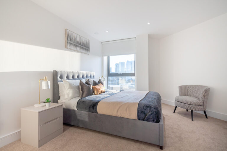 King size bed with the view of a window inside Canary View Apartment