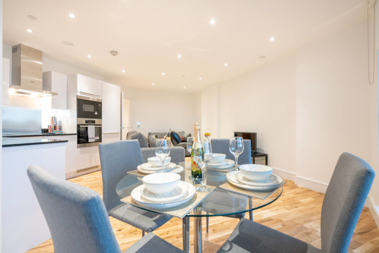 Dining table with cutlery and plates inside Canary View Apartment